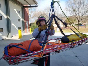 Photo of Leisa Davis in working with a gurney in the field